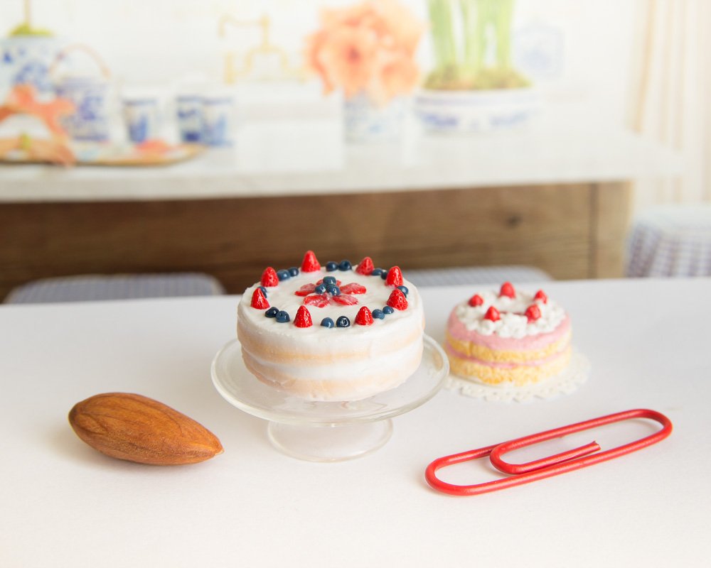 Food miniature in 1/12 scale. Strawberry and blueberry cake, with a standard (small) paperclip and an almond for scale.